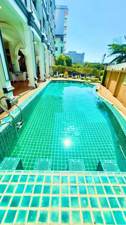 a swimming pool with green tiles in a building at APK Resort in Patong Beach