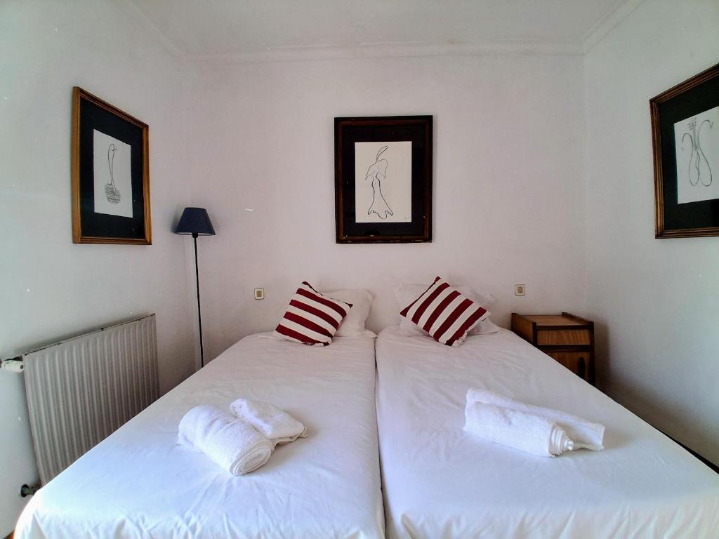two beds in a room with white sheets and pillows at Concha de Moledo in Moledo