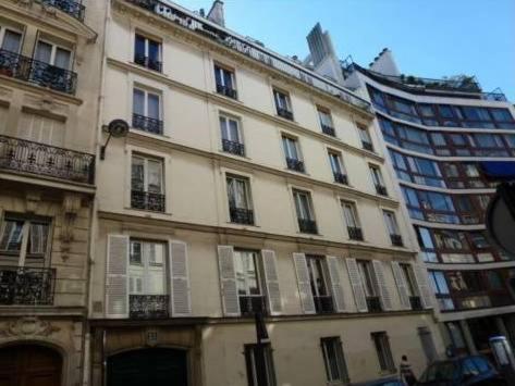 un grand bâtiment situé dans une rue à côté d'un grand bâtiment dans l'établissement Luxembourg Apartment, à Paris
