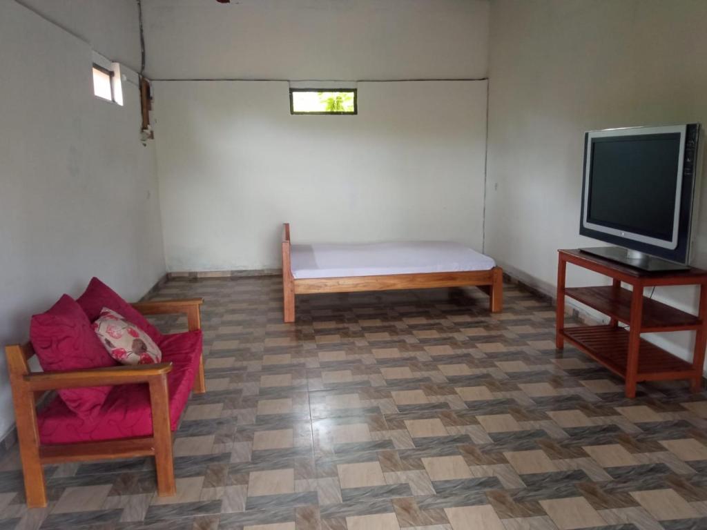 a living room with a couch and a tv at Villa Marie in Nosy Be