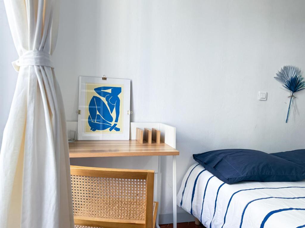 a bedroom with a bed and a desk with a picture at Superbe appartement spacieux, calme, central in Toulon