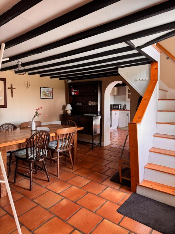 a kitchen and dining room with a wooden table and chairs at Sweet Lamb Farmhouse in New Ross