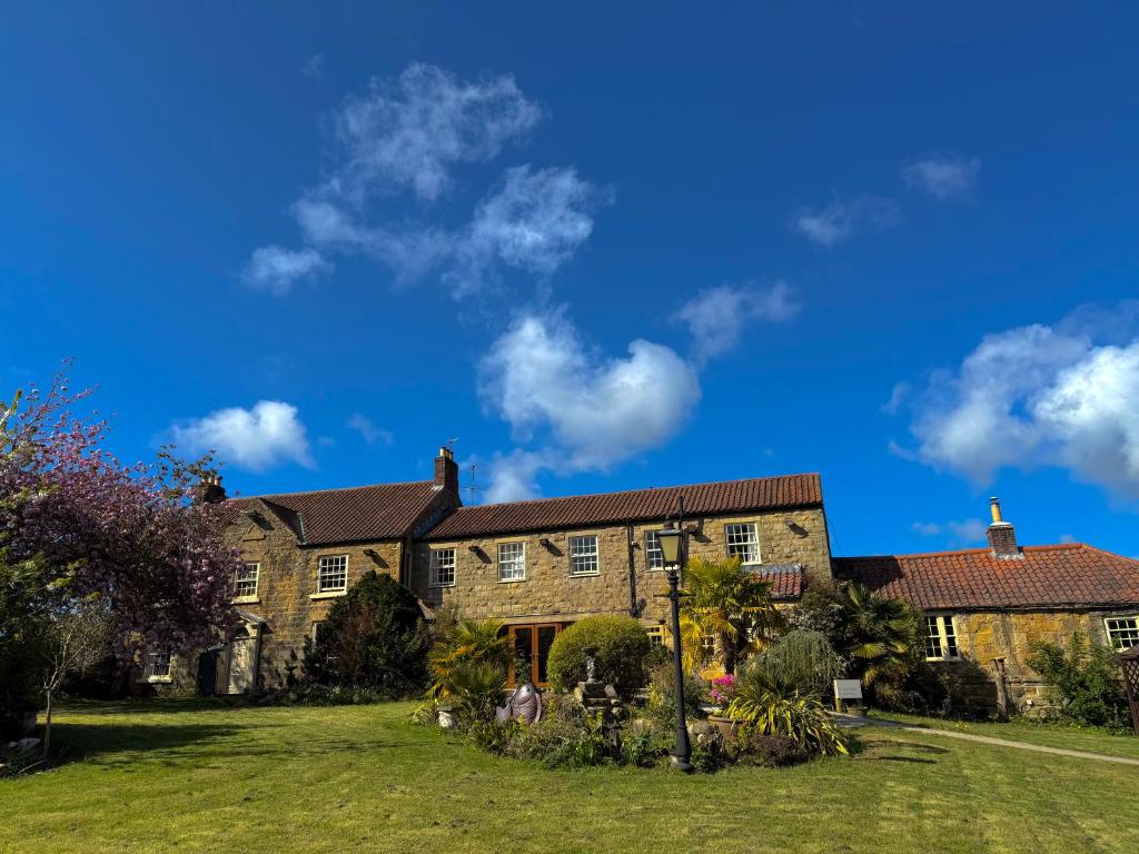 a large brick house with a grass yard at Asquith Hall Hotel & Spa Scarborough in Scarborough