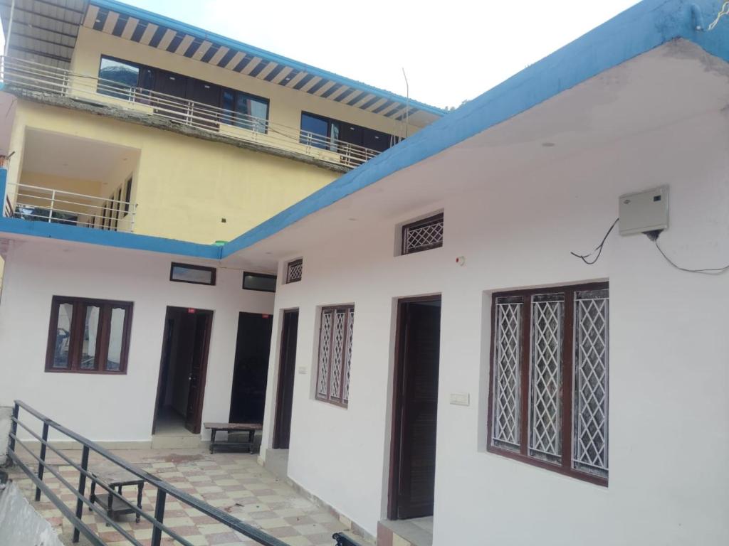 a white house with a blue roof at Royal Orbit By StayApart in Sonprayag