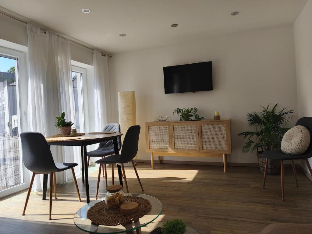 a living room with a table and chairs and a television at Herdecke, Ruhrperle in Herdecke