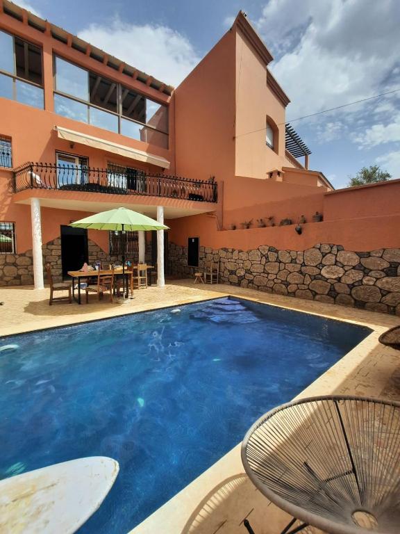 a swimming pool in front of a house at Apartment with pool next to the ocean in Agadir nʼ Aït Sa