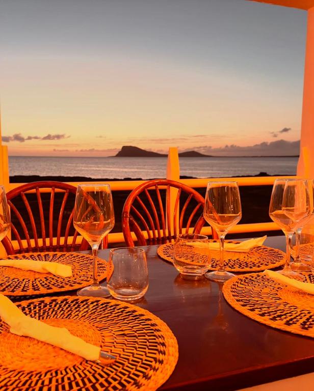 a table with plates and wine glasses on a balcony at Murdeira Village in Beirona