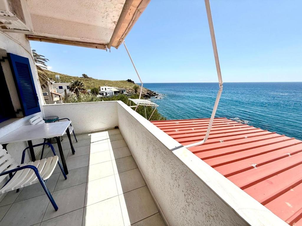 a balcony with a table and chairs and the ocean at Blue Thea in Lentas