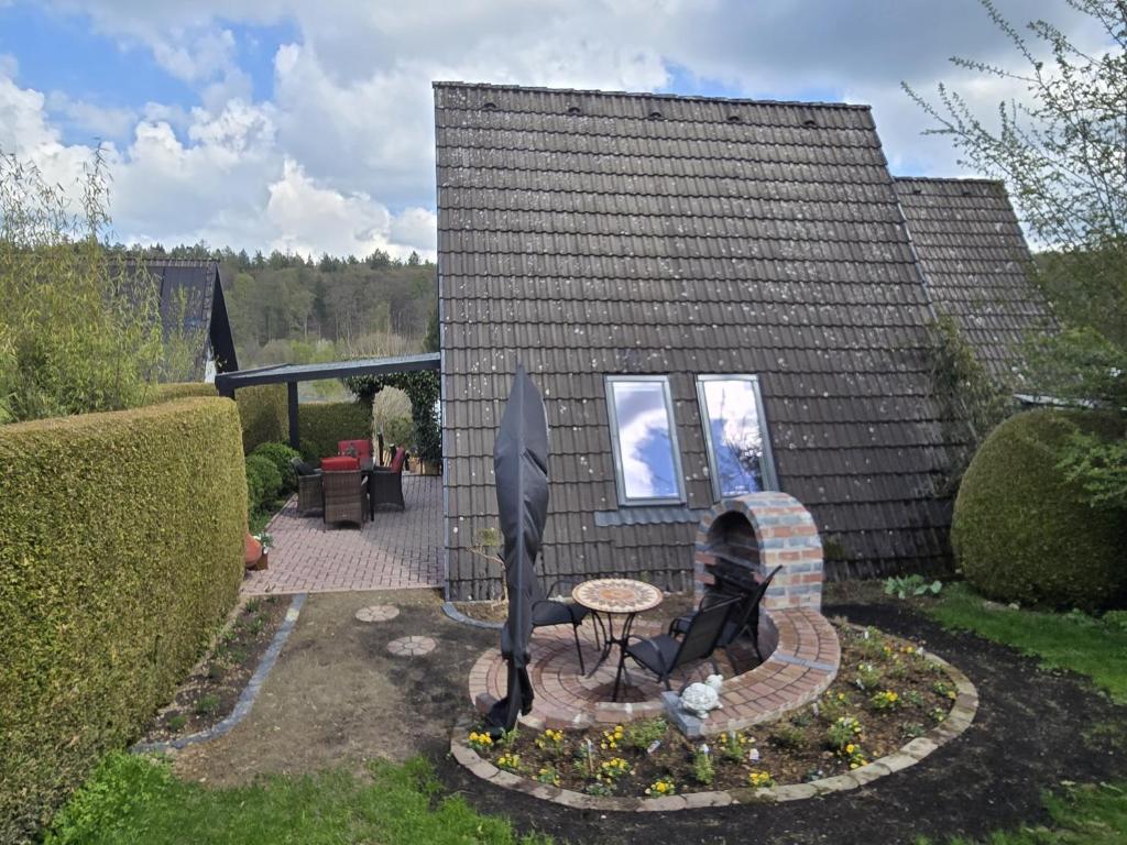 a garden with a table and a fire place at Haus Rosengarten 2 in Bad Wünnenberg