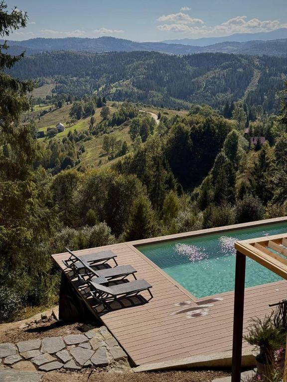 a swimming pool with lounge chairs on a wooden deck at Висота 890 in Volosyanka
