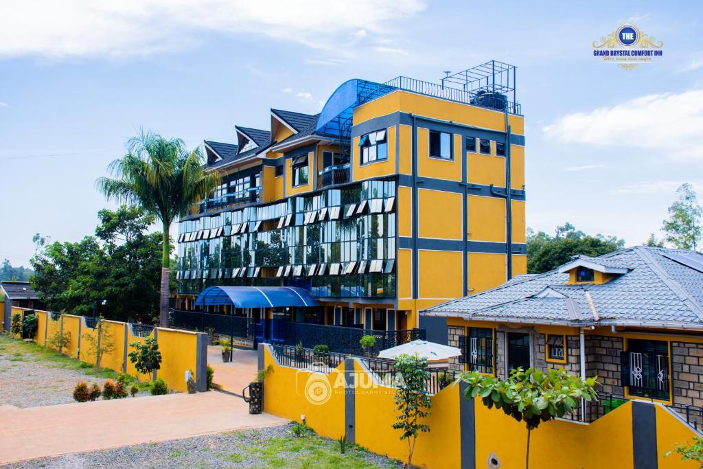 a yellow building with a blue roof at The Grand Brystal Hotel in Busia