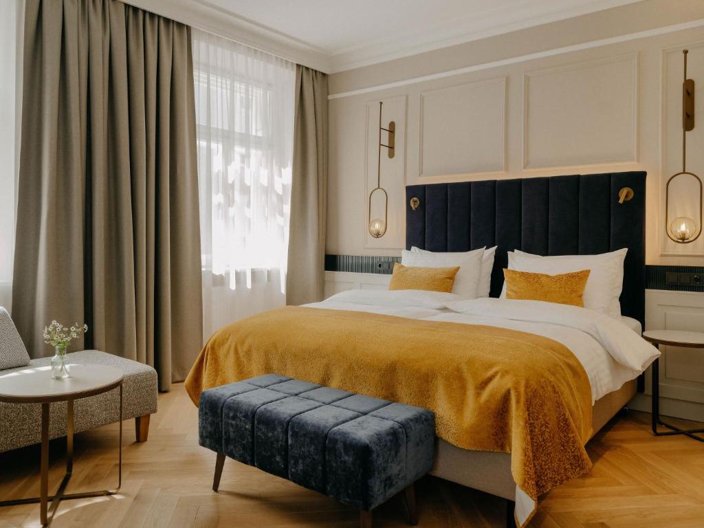 a bedroom with a large bed with a black headboard at IMLAUER Palais Mirabell in Salzburg