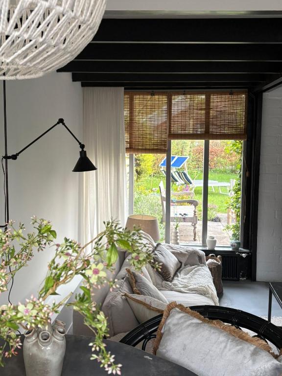 a living room with a couch and a large window at Seasons in Warmenhuizen