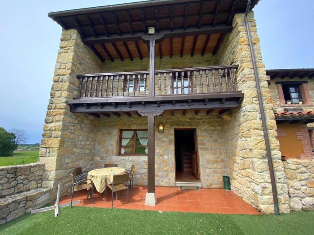 a building with a balcony and a table on a patio at La Helguera By Silastur in Colombres