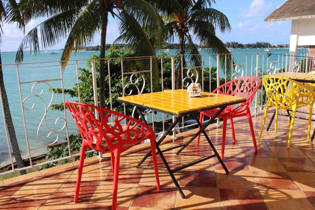 a table and chairs on a patio with the ocean at Ven OCEAN VIEW in Grand-Baie