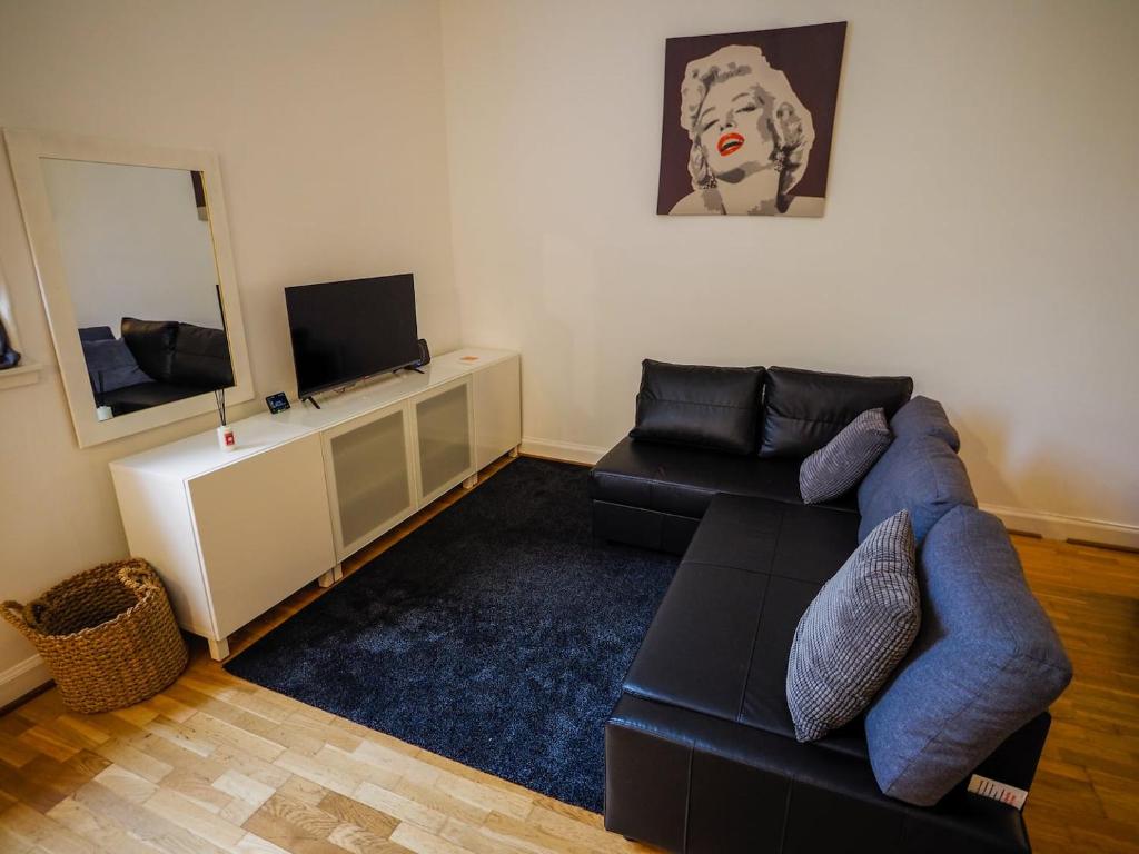 a living room with a blue couch and a mirror at Stylish Edinburgh Studio in Edinburgh