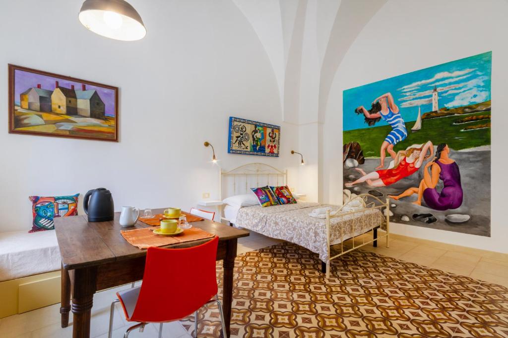 a living room with a bed and a dining table at GuestHost - Arkè Colorful Apartment in Giuggianello