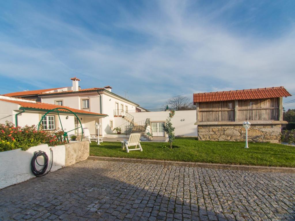 uma grande casa branca com uma entrada de tijolos em Quinta dos Avós em Viana do Castelo