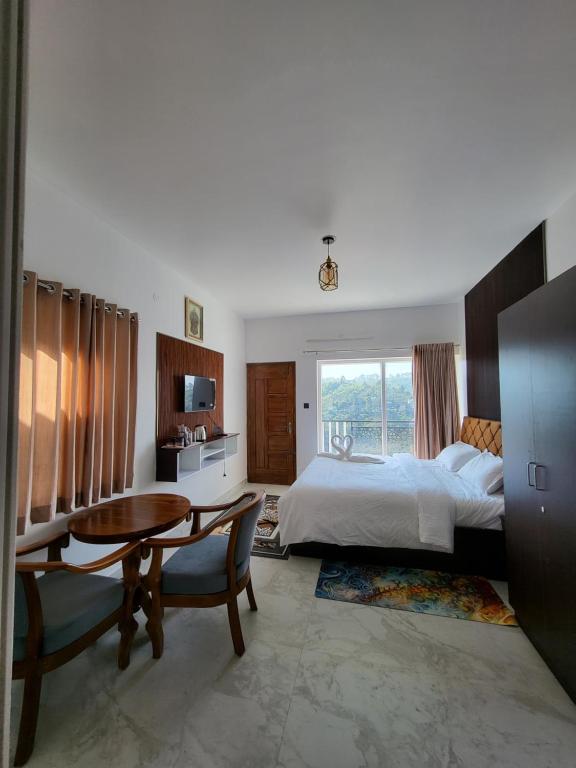 a bedroom with a bed and a desk and a table at The heights holidays in Kodaikānāl