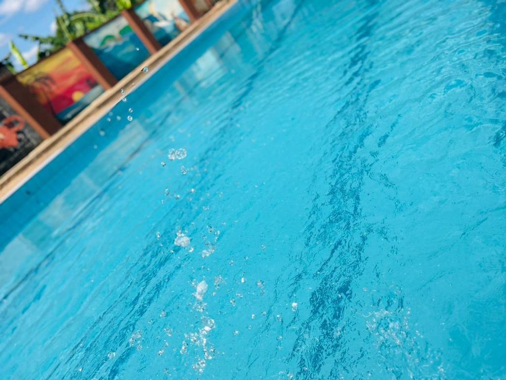 a swimming pool with blue water in a resort at Joster Hotel Kasangati in Kasangati