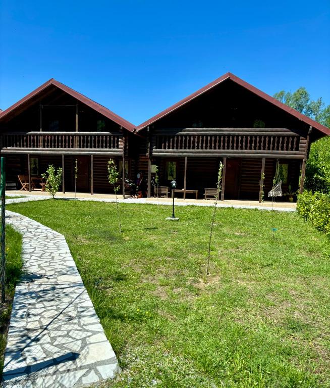 a large building with a grass yard in front of it at Virpazar Oaza in Virpazar