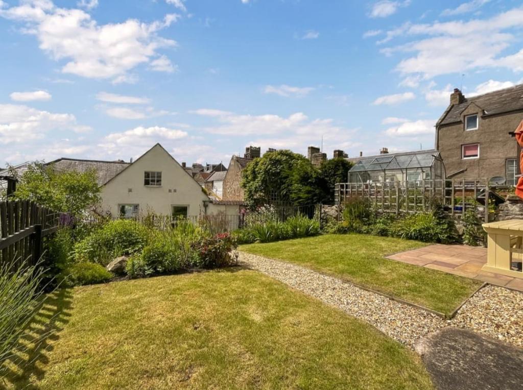 a garden with a fence and a yard at Borders Cottage in Coldstream