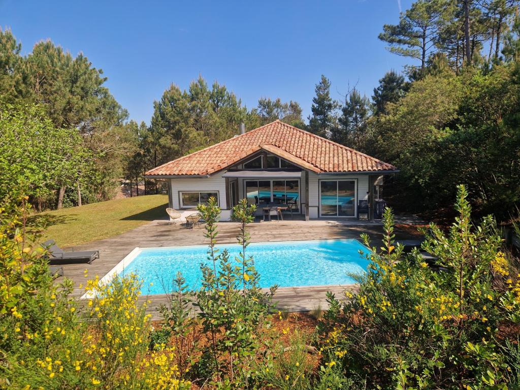 a house with a swimming pool in the yard at Pin Bleu in Moliets-et-Maa