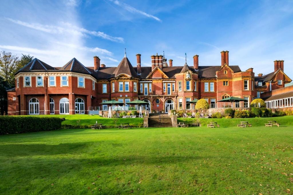 a large red brick building with a grass yard at Birmingham North Moor Hall Hotel BW Premier Collection in Sutton Coldfield