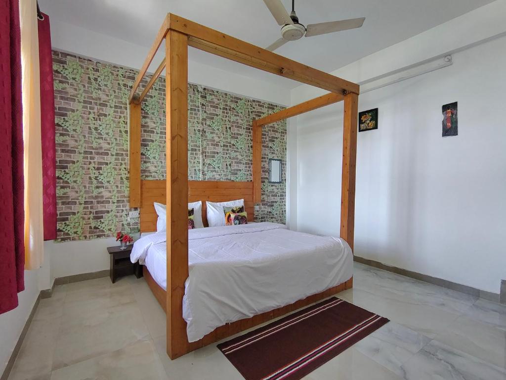 a bedroom with a canopy bed with a brick wall at Pinewood Sunrise Homestay Kasauli by Splendid Retreat Hotels in Kasauli