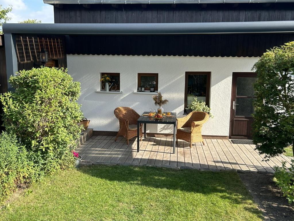 a patio with a table and chairs in a yard at Ferienhaus Hartmut Löschke in Rheinsberg