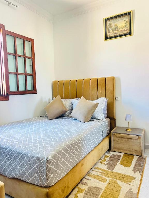 a bedroom with a bed with a wooden headboard at Cocon alpin -studio bien équipé in Ifrane