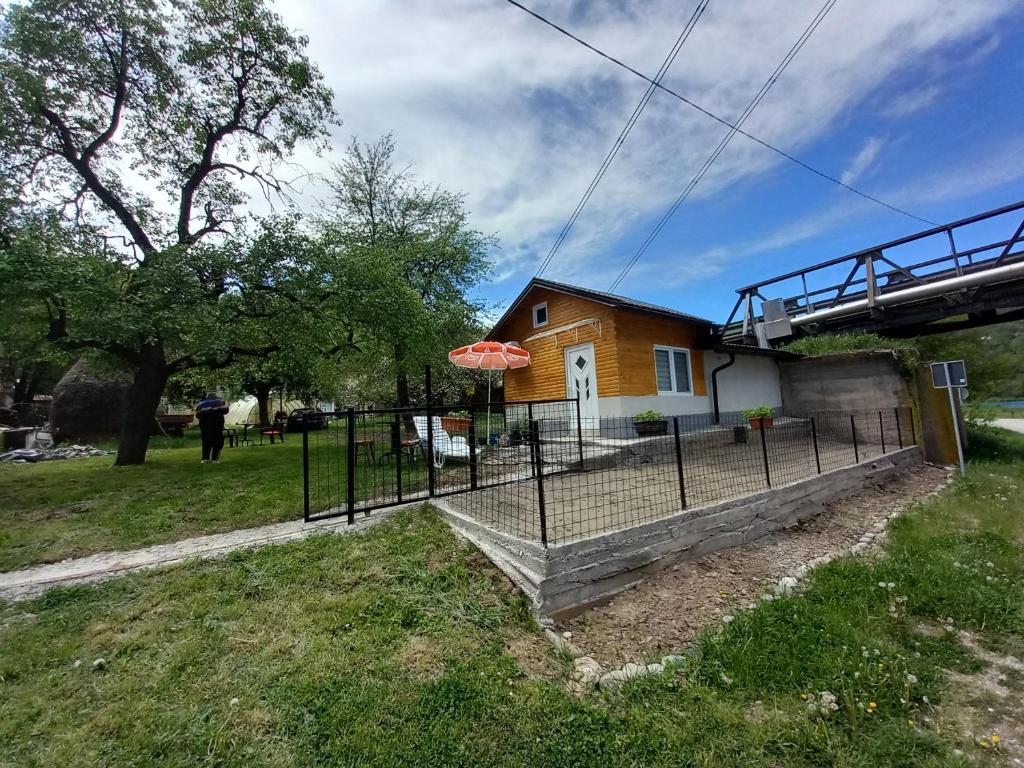a house with a fence and an umbrella at Apartman Sadba 2 in Goražde