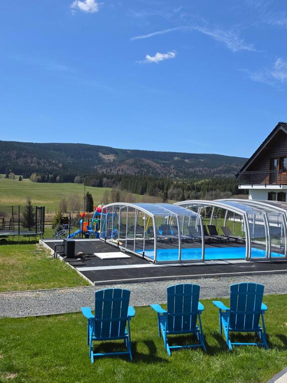 two blue chairs sitting in front of a water park at Jagodowy Ski&Spa pensjonat z widokiem na góry,podgrzewany basen zewnętrzny latem,bilard,świetne Wi-Fi,Restauracja,balia,sauna na miejscu in Lasowka