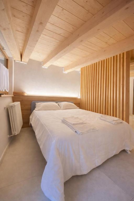 ein Schlafzimmer mit einem großen weißen Bett und einer Holzdecke in der Unterkunft Boutique Alpine Studio by SupaStays in Courmayeur