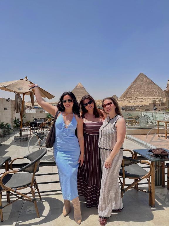 a group of women standing on a balcony with pyramids at Locanda Pyramids Hotel in Cairo