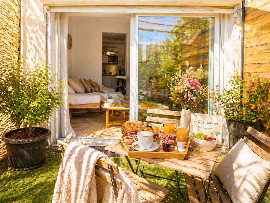 a table with food on it on a patio at Le Clos Lassagne -Terrasse privative - Climatisation - Lyon Sud - Brignais in Brignais