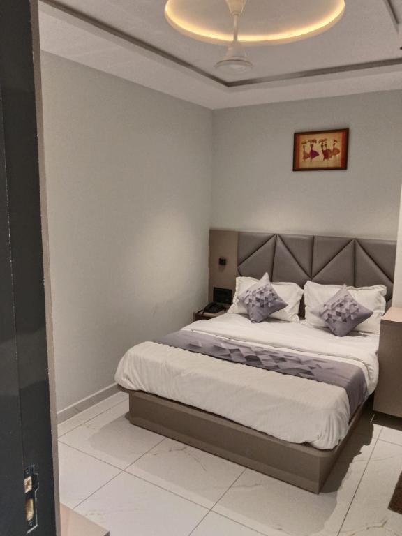 a bedroom with a large bed with a white bedspread at Hotel Bellemount in Ahmedabad