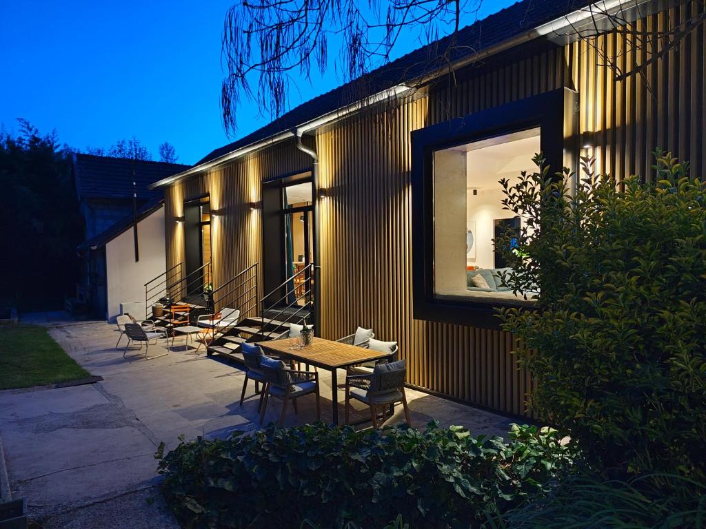 a patio with a table and chairs next to a building at Le 10, Reflets dans l'Eau in Saint-Clair-de-la-Tour