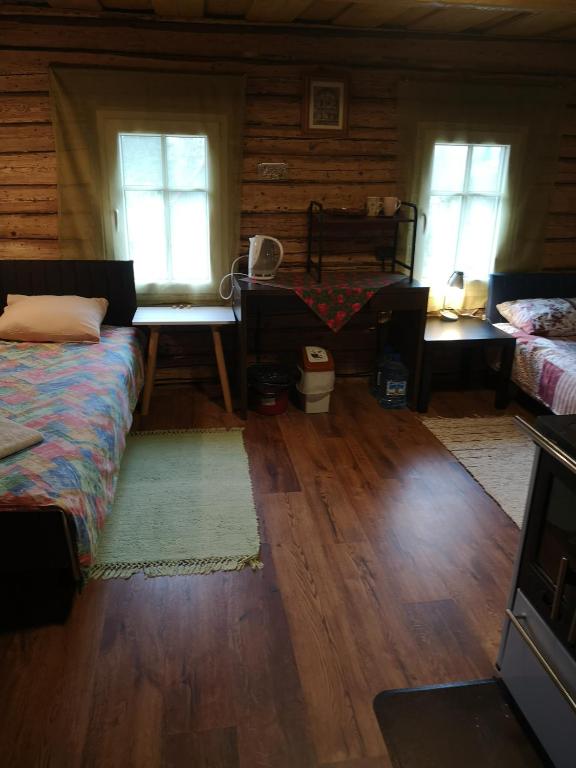 a living room with two beds and two windows at Köleri B&B in Suure-Jaani