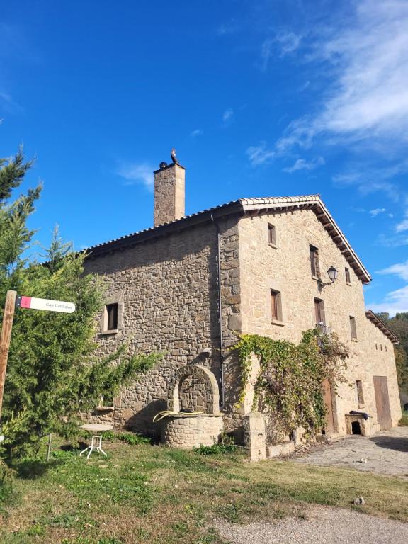an old stone building with a chimney on top at Can Cuti in Santa Eulalia de Ríuprimer
