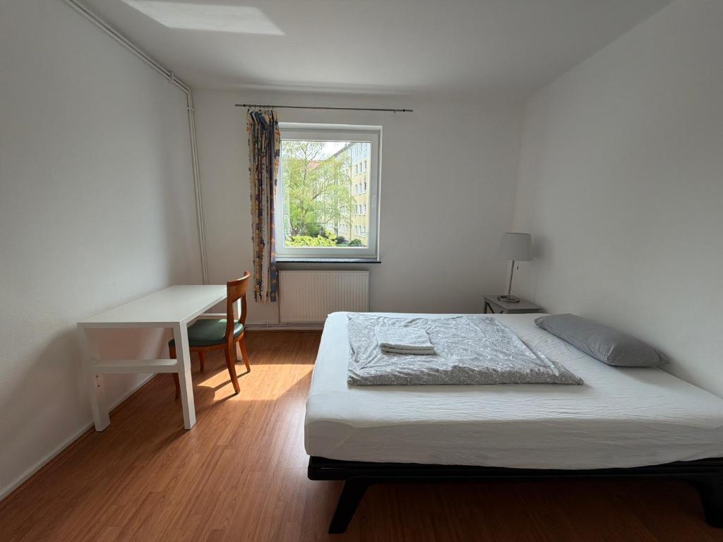 a bedroom with a bed and a desk and a window at Guestroom Hannover Messe in Hannover