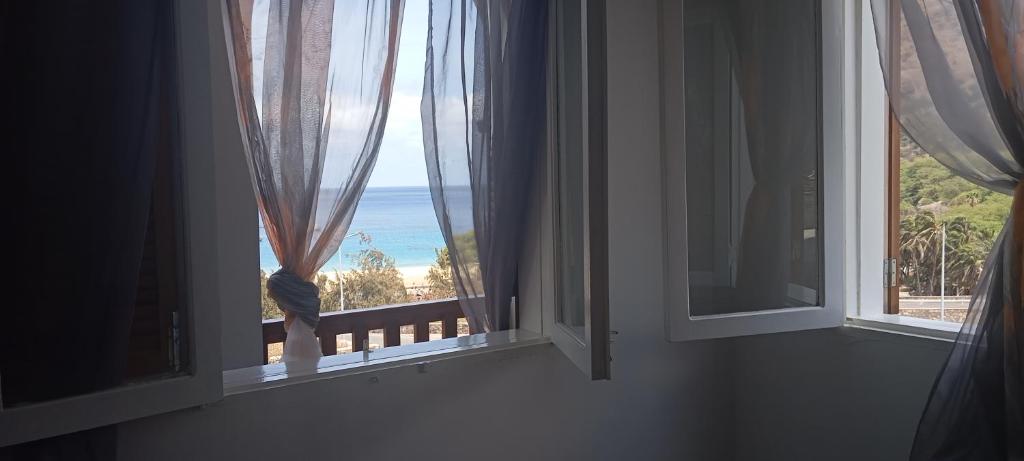 a room with two windows with a view of the ocean at Casa Silvina Tarrafal in Tarrafal