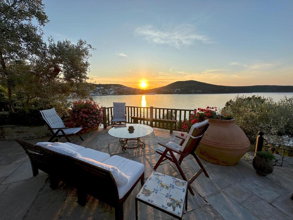 a patio with chairs and a table and a sunset at Villa Mitzela in Amaliapoli