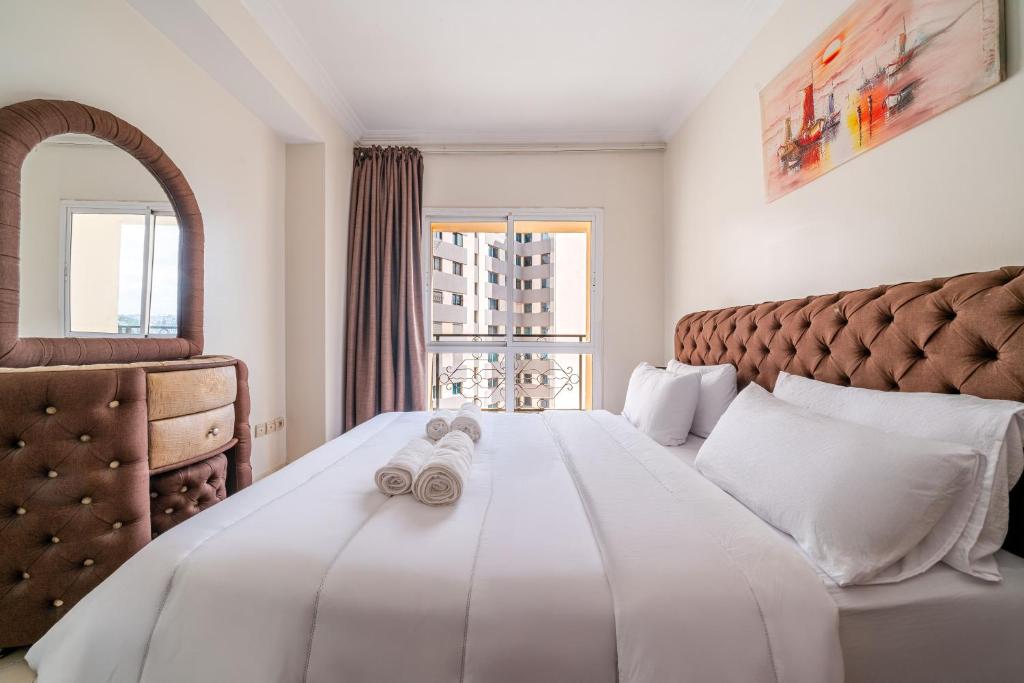 a bedroom with a white bed with towels on it at First Line Beach & Free Parking in Tangier