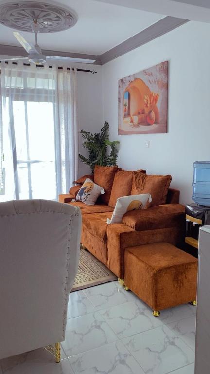 a living room with a brown couch and a window at Malindi Leisure homes in Malindi