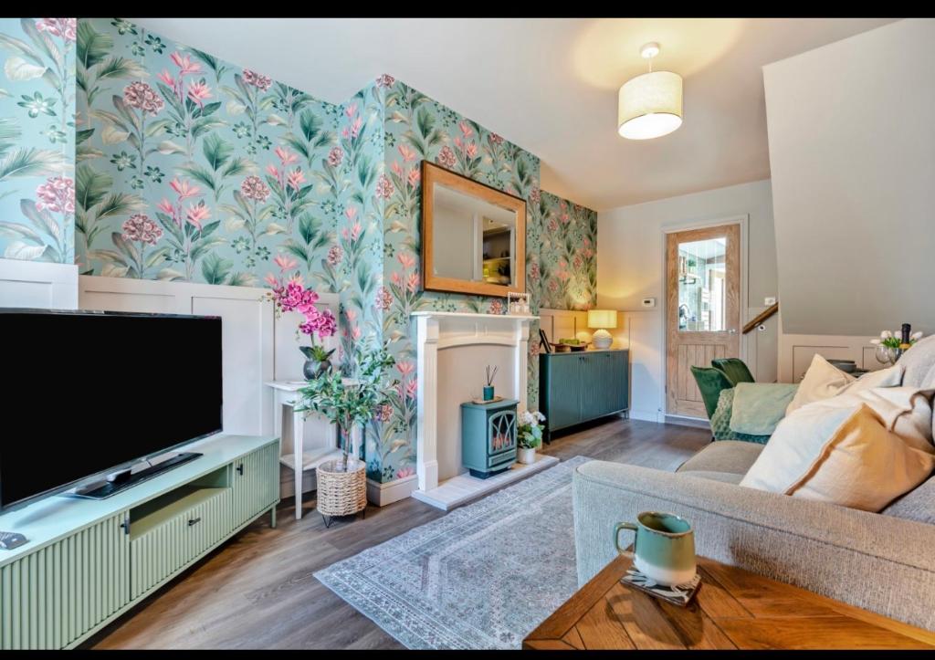 a living room with a tv and a couch at Ivydene Cottage Hawsker in Whitby