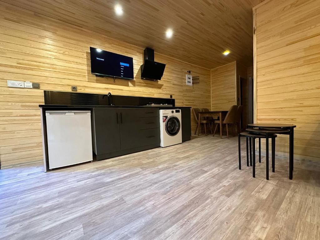a laundry room with a washer and a tv on a wall at Nirvana Suite Hotel in Uzungöl
