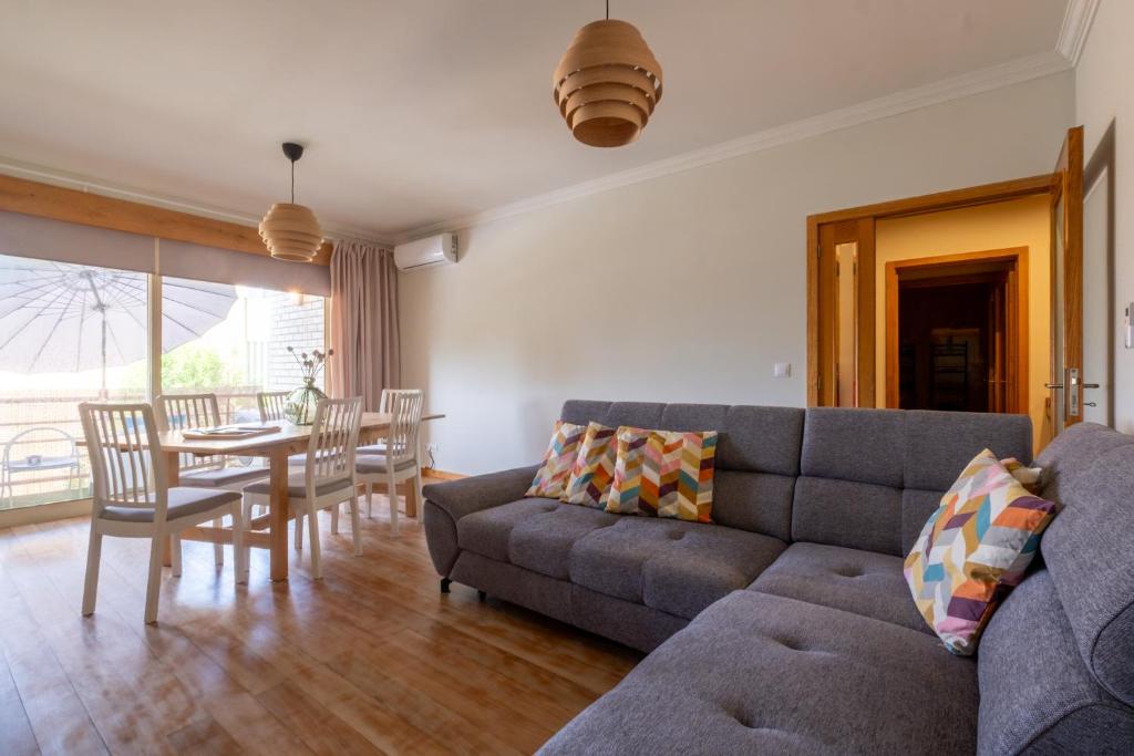 a living room with a couch and a table at FamilyHub - EcoHost - Spacious 3-bedroom apartment for 8 people with AC and parking near Porto and the beaches in Senhora da Hora