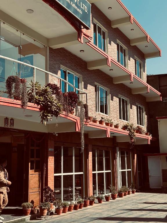a building with potted plants on the side of it at Prashiddha Resort in Dakshīnkāli
