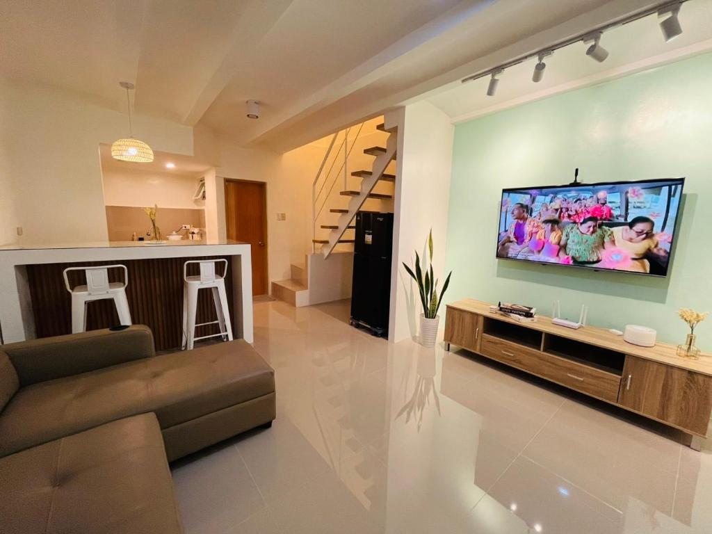 a living room with a large flat screen tv on a wall at Casa Serenity Transient House in General Trias